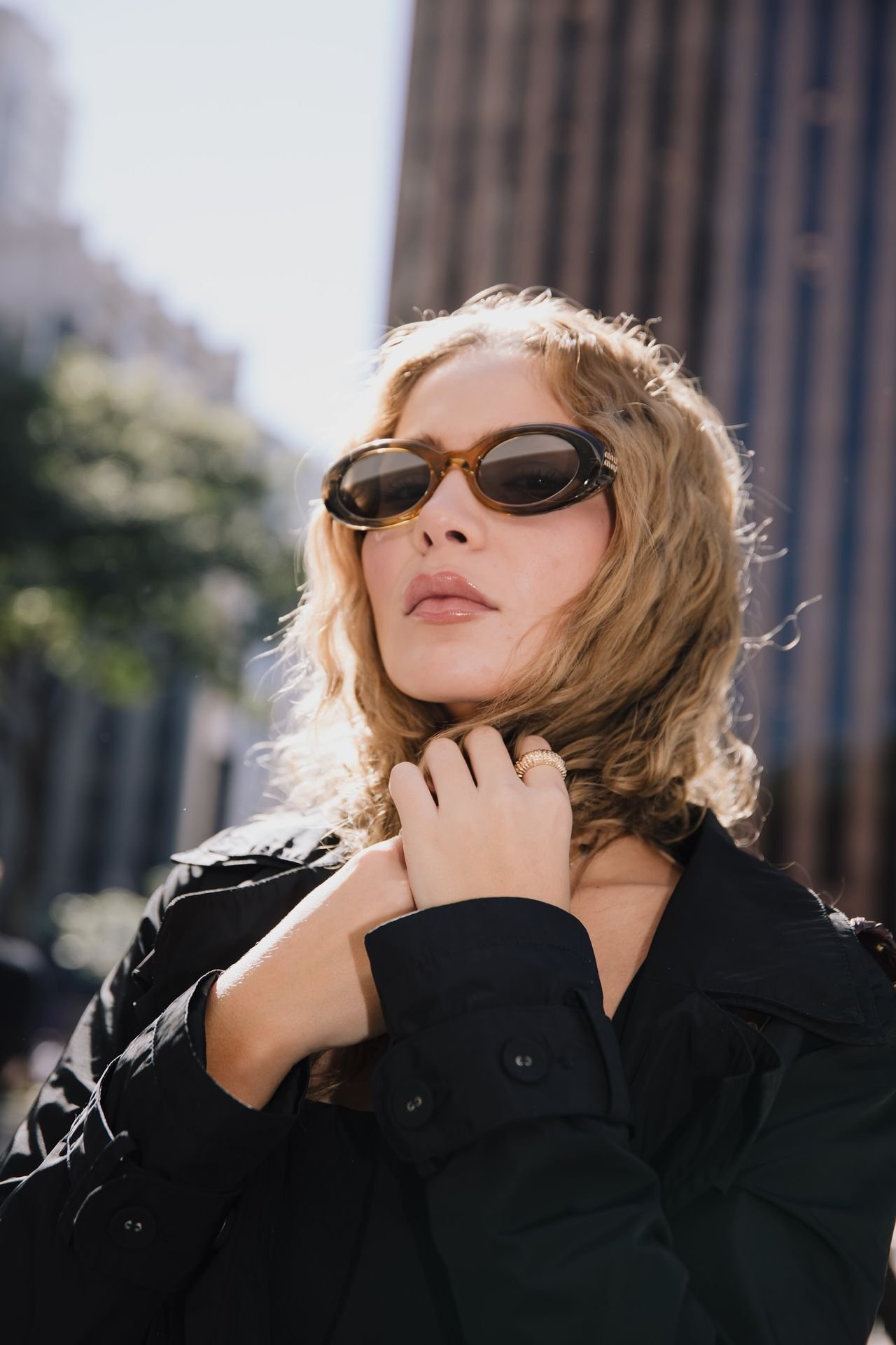 Retrato aproximado de mulher com óculos de sol e cabelos cacheados